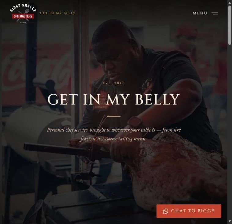 Biggy Smallz homepage: the 'Get in my belly' hero over Biggy carving a whole roasted lamb off the spit rig, logo and menu in the nav bar up top.